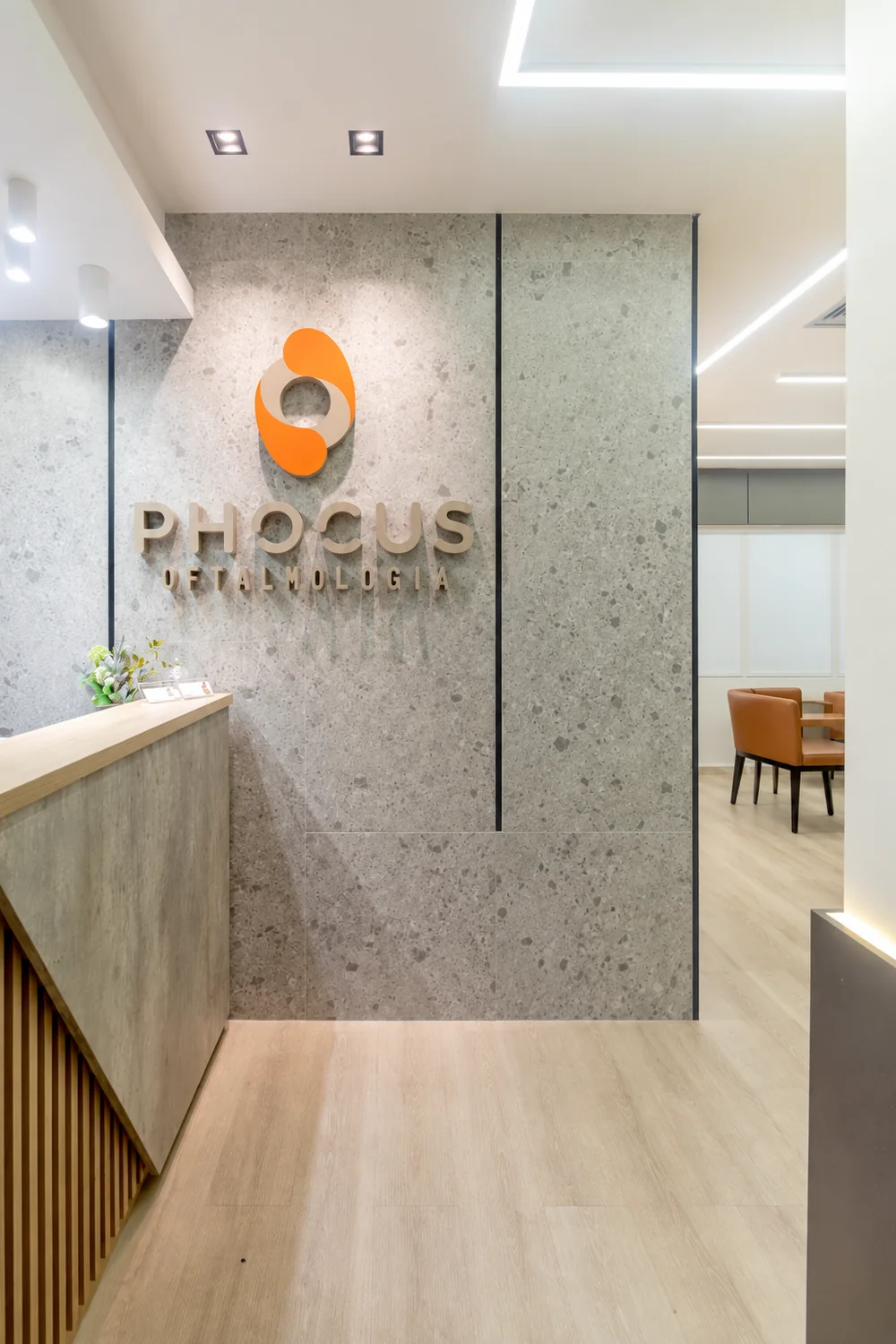 Recepção da Phocus Oftalmologia, com parede de pedra e logotipo da clínica
